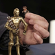 Babu Frik and C-3PO, who has a bowcaster and bandolier.